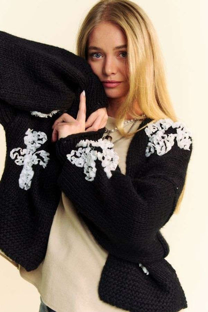 White floral appliqué and chunky knit sleeve detail