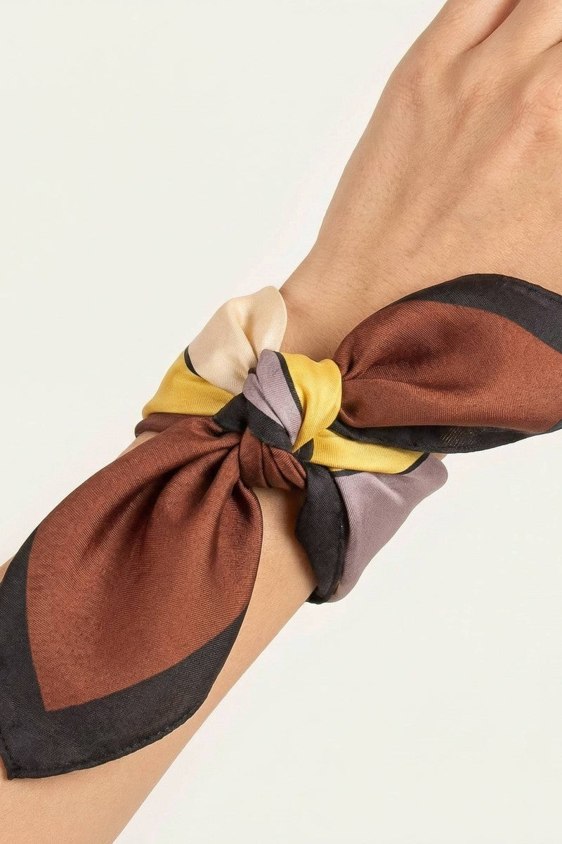 Brown multicolor scarf tied around wrist